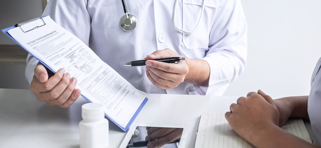 Doctor consulting with patient and checking their condition with a form. 